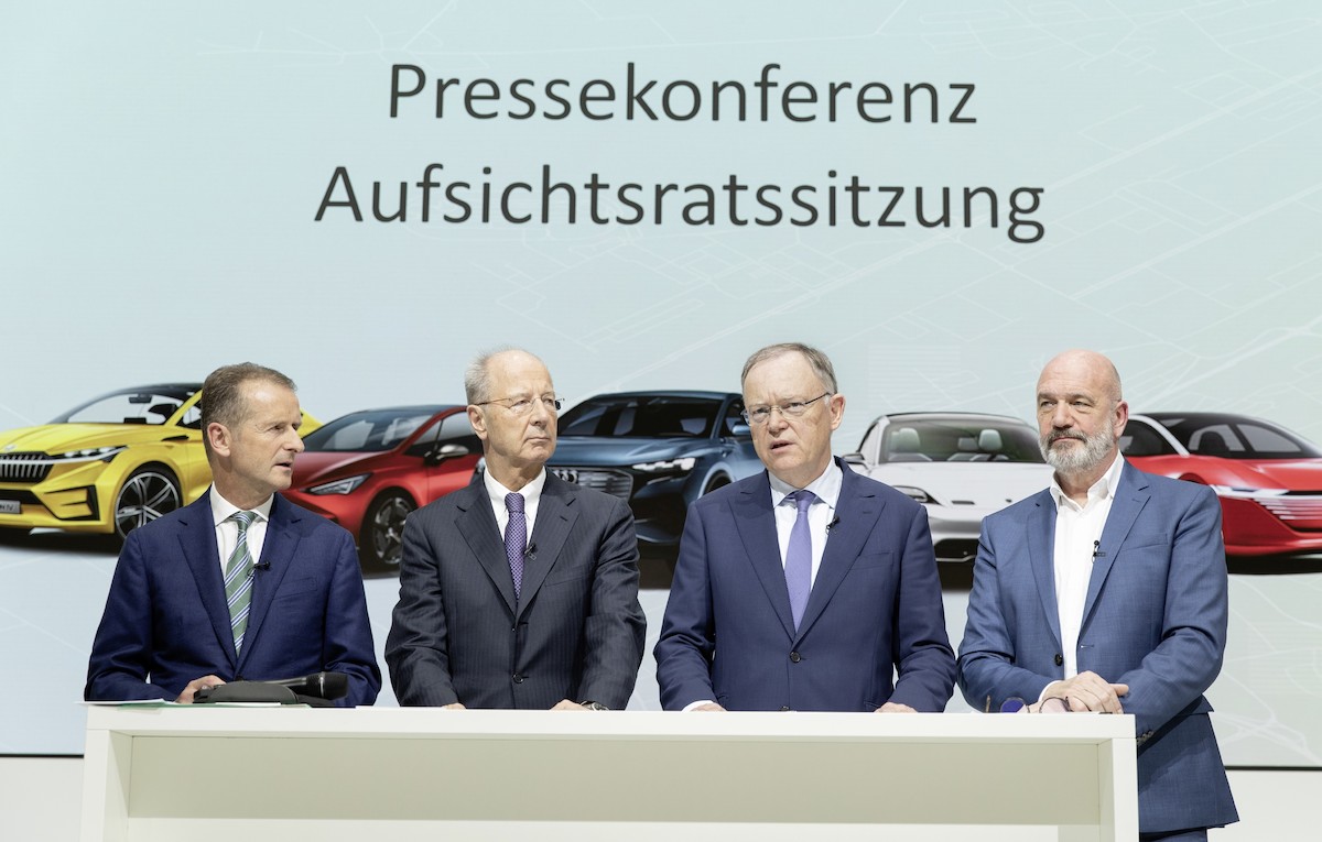 four cars in front of a rocky coast